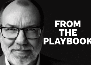 MAN WITH GLASSES WITH FORM THE PLAYBOOK IN LETTERS NEXT TO HIMI